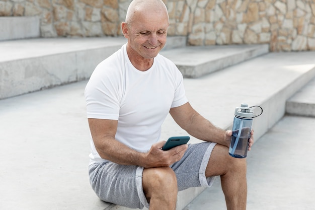 Uśmiechnięty Starszy Mężczyzna Cheking Jego Telefon