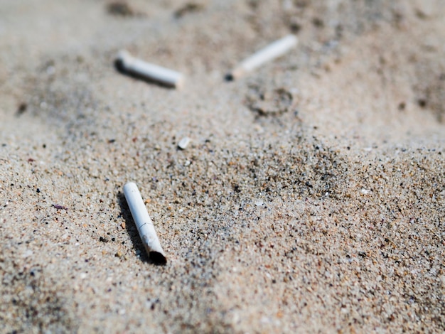 Używane niedopałki papierosów na piasku na plaży