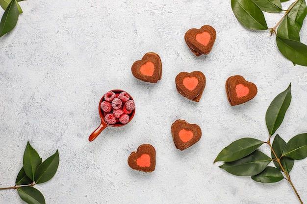 Valentine ciasteczka w kształcie serca z mrożonymi malinami na świetle
