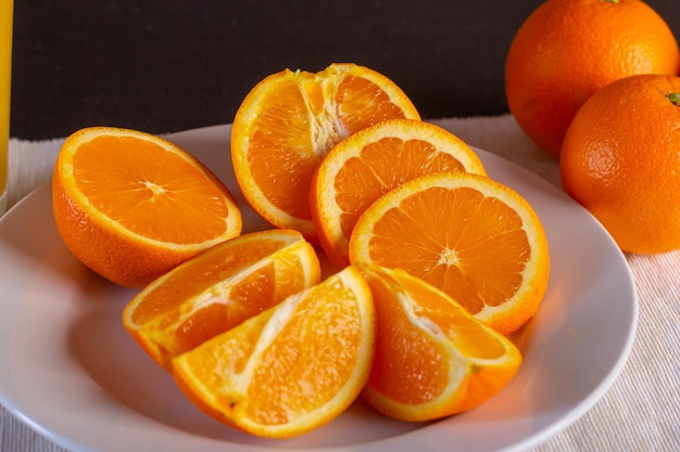 Varias naranjas cortadas en un plato blanco, vista cerrada, vista cercana de fruta fruta