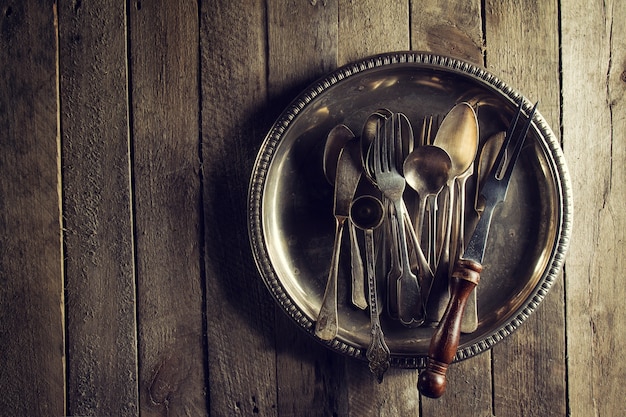 Bezpłatne zdjęcie vintage stare rustykalne przyborów kuchennych widelce łyżki i nozy na starym drewnianym stole. żywności lub vintage rustic concept. widok z góry.