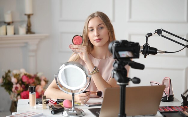 Vlogger kosmetyczny. Młoda kobieta nagrywa samouczek makijażu