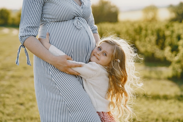 Bezpłatne zdjęcie w ciąży matka z córką w polu