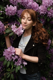 W parku liliowym przebywa dziewczyna o wyjątkowym wyglądzie. portret dziewczynki z wiosennych kwiatów. 8 marca dzień kobiet. dziewczyna na tle kwiatów
