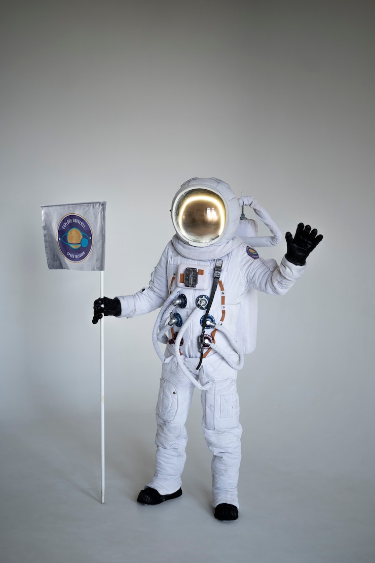 Bezpłatny plik Zdjęcie w pełni wyposażony astronauta mężczyzna trzymający flagę