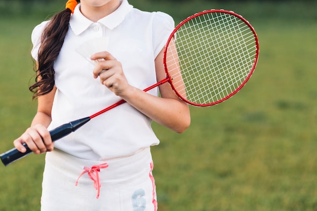 Bezpłatne zdjęcie w połowie sekcja dziewczyny mienia badminton w ręce i shuttlecock