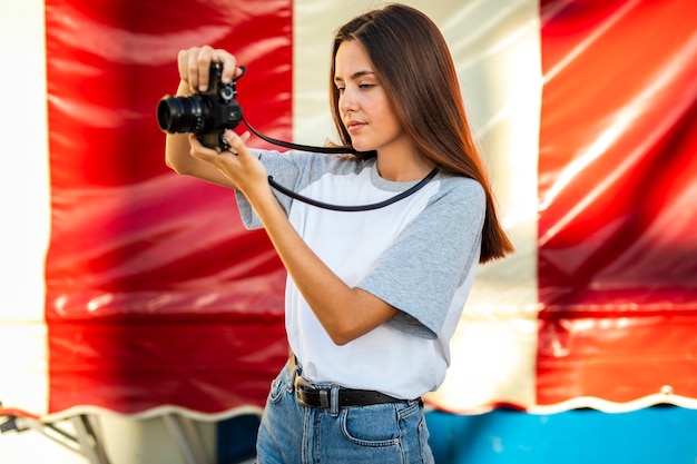 Bezpłatne zdjęcie w połowie strzał kobieta bierze fotografię z kamerą