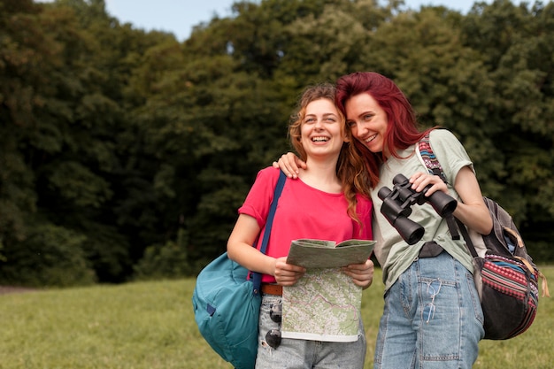 W połowie zdjęcia dziewczyny z lornetką i mapą w naturze