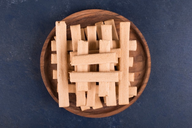 Bezpłatne zdjęcie wafel kije w stos w drewnianym talerzu, widok z góry