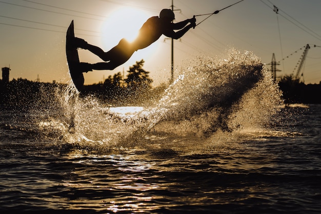 Bezpłatne zdjęcie wakeboard. wakeboarding skoki o zachodzie słońca