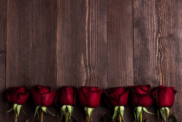 Walentynki dzień matki kobiet czerwona róża prezent niespodzianka na ciemnym drewnie
