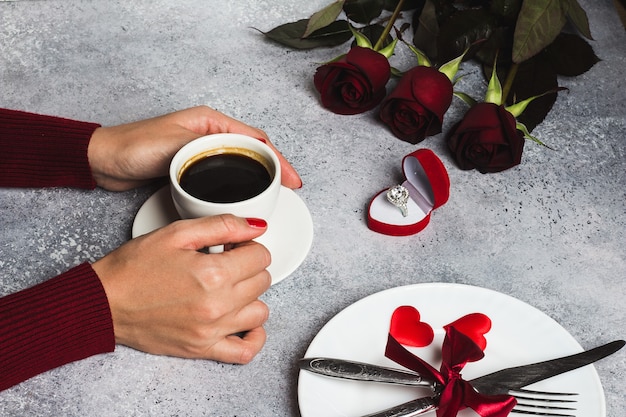 Walentynki-dzień romantyczny stół ustawienie kobieta ręka trzyma filiżankę kawy