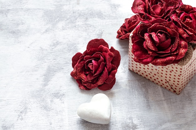 Bezpłatne zdjęcie walentynki prezent z ozdobnymi różami i białym sercem na jasnym tle kopii przestrzeni.