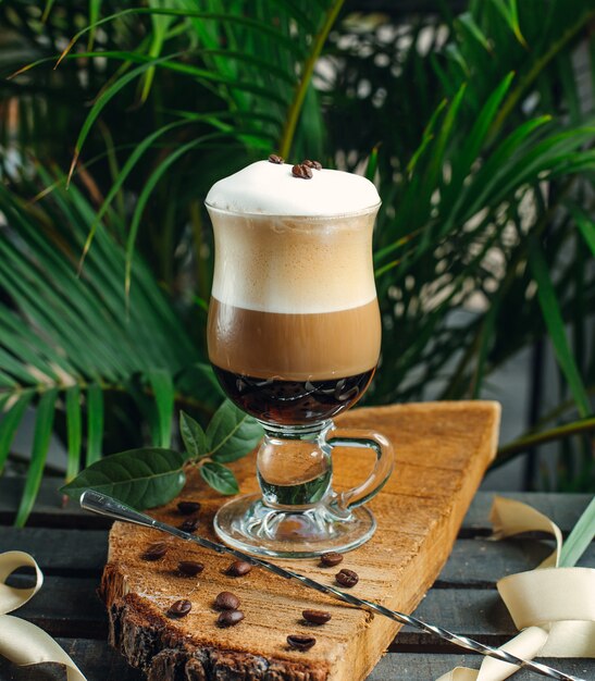 warstwowa kawa ze śmietaną i ziarnami kawy na rustykalnej desce