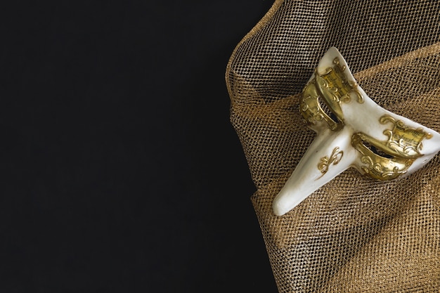 Bezpłatne zdjęcie weneckie maski z długim nosem na złotej tkaniny