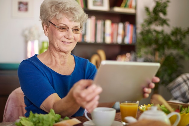 Wesoła babcia za pomocą cyfrowego tabletu het