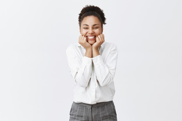 Wesoła i urocza afroamerykańska pracownica biurowa wyglądająca na zachwyconą, uśmiechnięta rozbawiona