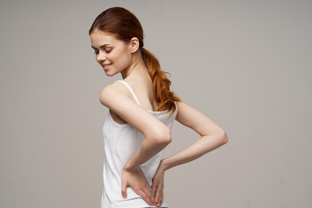 Wesoła kobieta w białej koszulce rozgrzewki ramiona zdrowia. zdjęcie wysokiej jakości