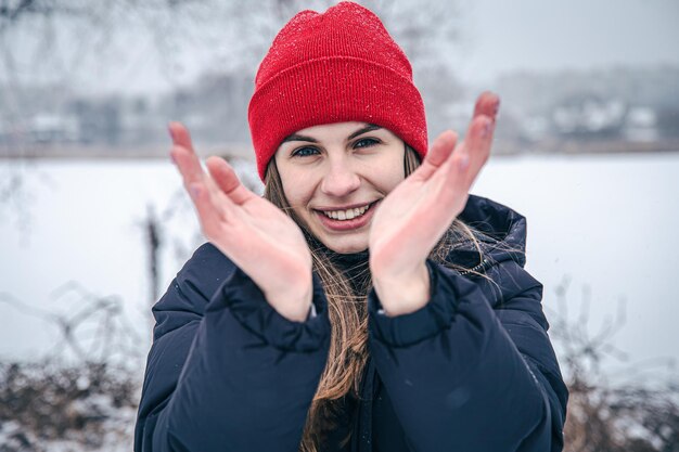 Wesoła młoda kobieta zamarła w dłoniach z zimna