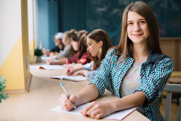 Wesoła studentka nastolatka z kolegami z klasy