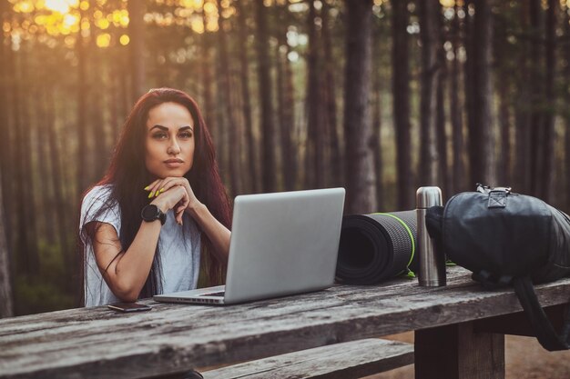 Wesoły Młody Student Pracuje Na Laptopie W środku Lasu.