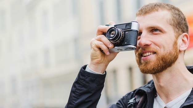 Bezpłatne zdjęcie wesoły przystojny fotograf