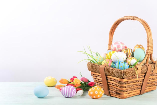 Wesołych Świąt Wielkanocnych pisanki w koszyku na drewnianym rustykalnym stole do dekoracji na wakacje