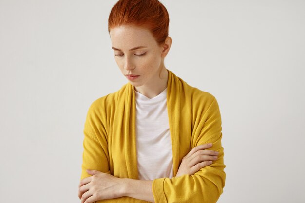 Wewnątrz portret pięknej rudowłosej kobiety w żółtej pelerynie, trzymającej ręce skrzyżowane, spoglądającej w dół ze smutnym wyrazem twarzy, myślącej nad czymś. Kobieta z rudymi włosami i pewnym siebie spojrzeniem