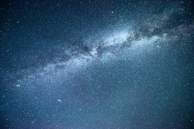 Wibrujące nocne niebo z gwiazdami, mgławicą i galaktyką.