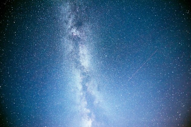 Wibrujące nocne niebo z gwiazdami, mgławicą i galaktyką.