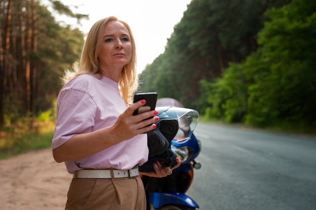 Bezpłatne zdjęcie widok boczny chłodna stara kobieta z motocyklem