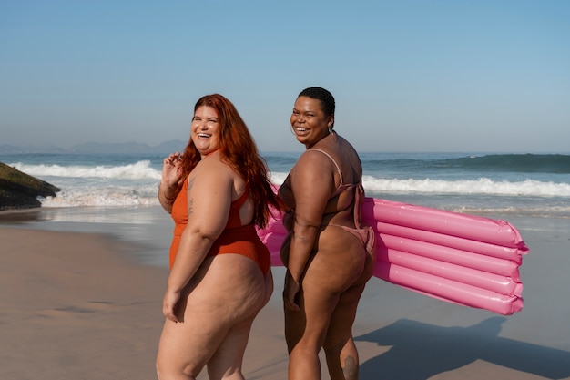 Bezpłatne zdjęcie widok boczny na kobiety w rozmiarze plus pozujące nad morzem