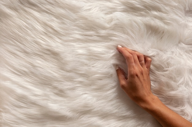 Bezpłatne zdjęcie widok dłoni przechodzącej przez teksturowaną tkaninę futrzaną