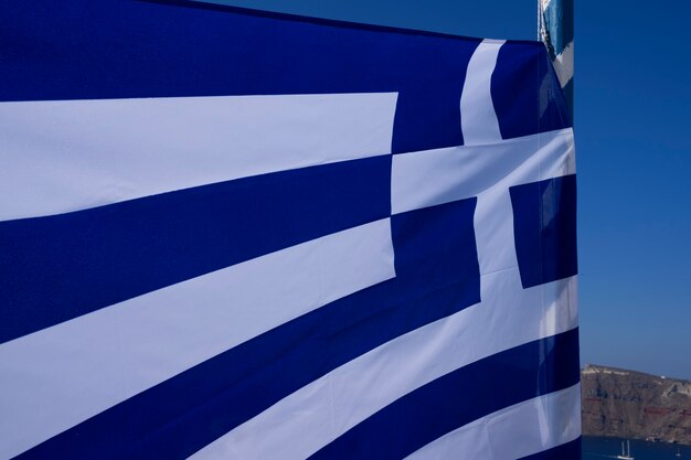 Widok greckiej flagi na wietrze, Oia, Santorini, Grecja