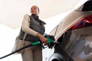 Bezpłatne zdjęcie widok kobiety z samochodem na stacji benzynowej