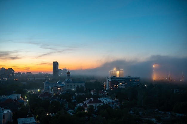 Widok na budynki mieszkalne o zachodzie słońca z pochmurnego nieba.