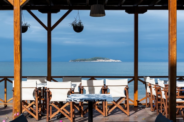 Widok na wyspę i Morze Egejskie z pustej restauracji