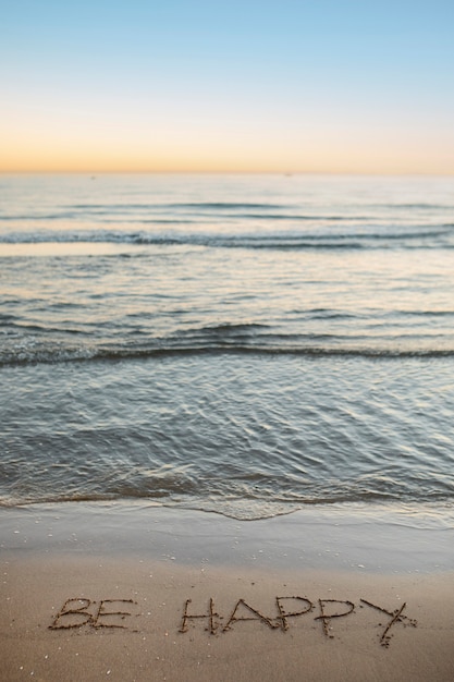 Bezpłatne zdjęcie widok piasku na plaży w lecie z napisaną w nim wiadomością