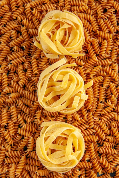 Widok pionowy i zdjęcie w wysokiej rozdzielczości różnych surowych włoskich makaronów ustawionych w rzędzie