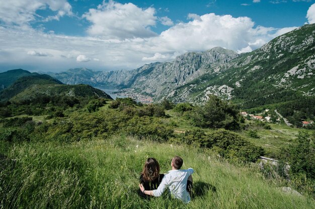 Widok romantycznej pary z tyłu cieszyć się widokiem na góry w słoneczny dzień w Czarnogórze