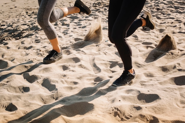 Widok stóp kobiety jogging na piasku