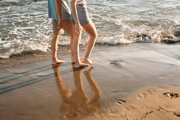 Widok stopy para chodzenia na plaży