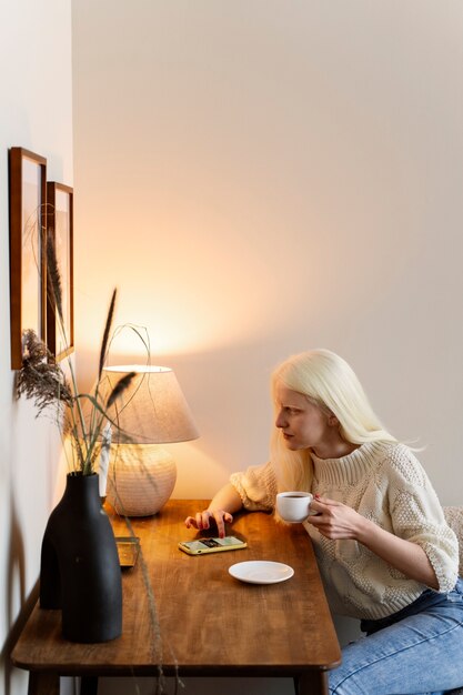 Widok z boku albinos kobieta siedzi przy stole