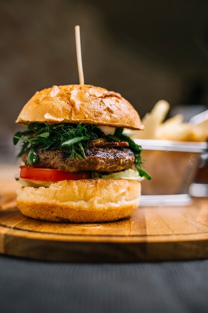 Widok z boku burgera z kotletem mięsnym na drewnianej desce