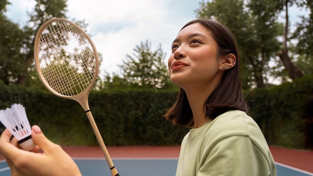 Bezpłatne zdjęcie widok z boku buźka kobieta grająca w badmintona