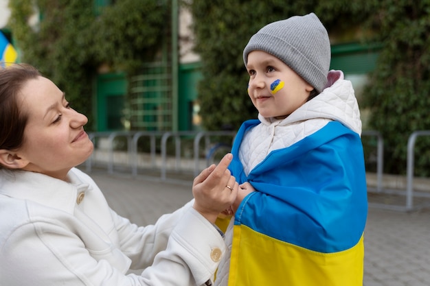 Bezpłatne zdjęcie widok z boku buźka matka i dziecko z flagą