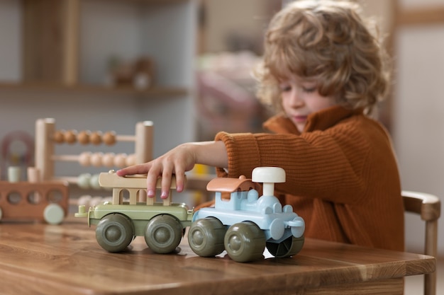 Bezpłatne zdjęcie widok z boku chłopiec bawiący się ekologicznymi zabawkami
