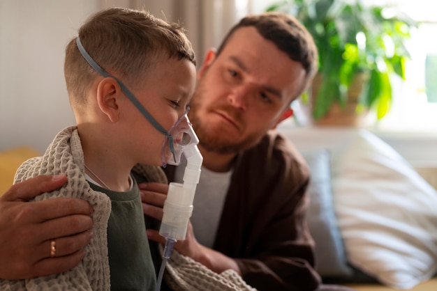 Bezpłatne zdjęcie widok z boku chorego dziecka za pomocą nebulizatora