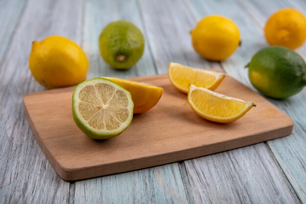 Widok z boku ćwiartki limonki z pół pomarańczy i cytryny na desce do krojenia