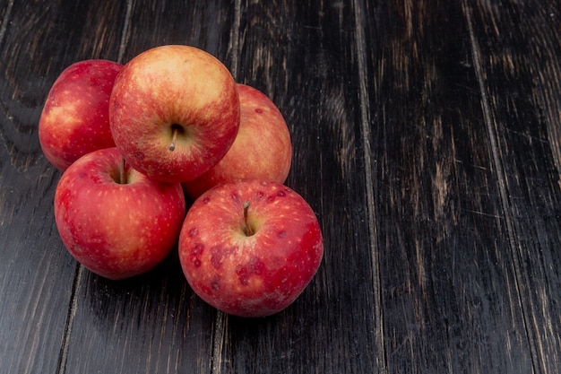 Widok z boku czerwonych jabłek na powierzchni drewnianych z miejsca na kopię